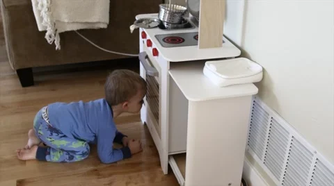 A boy playing with his toy kitchen Stock Footage 46859596