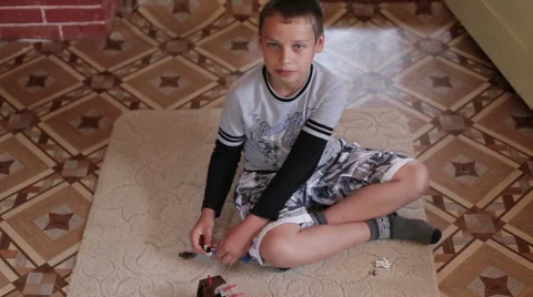A boy playing home sitting on the carpet Stock Footage 65776632