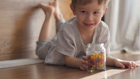 Boy playing with jar of candies Stock-Footage 85595188