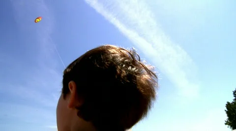 Boy playing with kite over blue sky 動画素材 496823