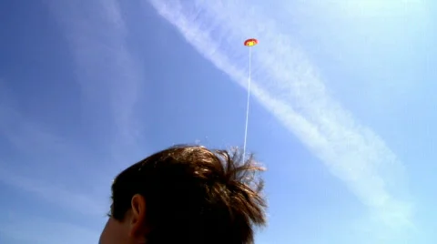 Boy playing with kite over blue sky Stock Footage 496827