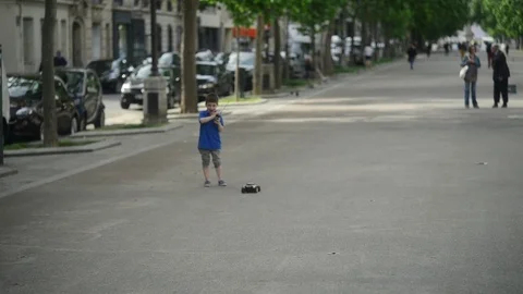 Boy playing machine radio controlled on the streets of Paris Stock Footage 76188960