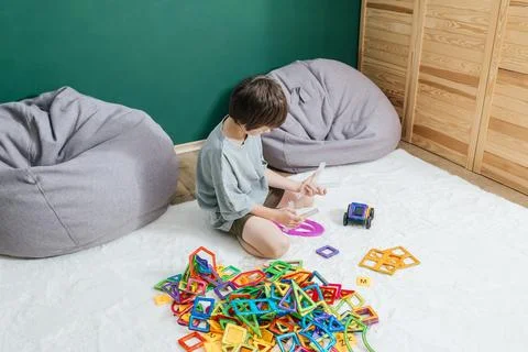 Boy playing with magnetic building blocks on a rug Stock Photos