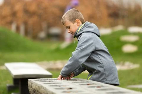 Boy playing mancala with himself Stock Photos