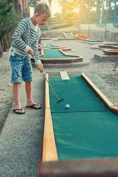 Boy playing mini golf on the territory of the hotel Stock Photos