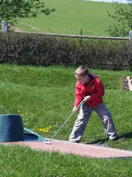 Boy playing minigolf Stock Photos