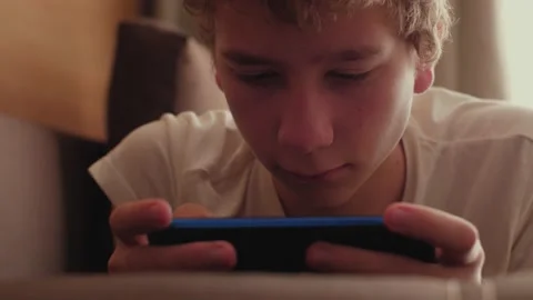 Boy playing mobile game Stock Footage 158145010