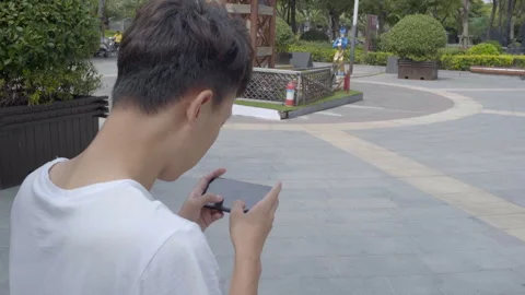 Boy playing mobile game happily Stock Footage 240973595