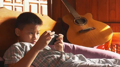 Boy playing mobile game on smartphone 動画素材 141730746