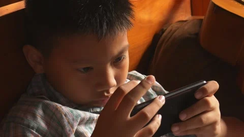 Boy playing mobile game on smartphone 動画素材 141857647
