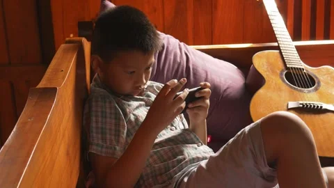 Boy playing mobile game on smartphone 動画素材 141857655
