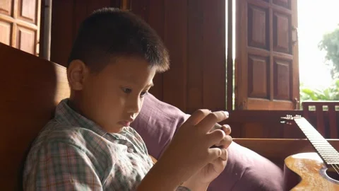 Boy playing mobile game on smartphone Stock Footage 141857695