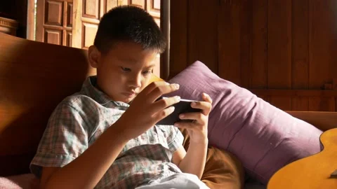 Boy playing mobile game on smartphone 動画素材 141857723