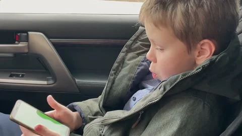 Boy playing mobile game on smartphone holding smartphone with green screen Stock Footage 172211911