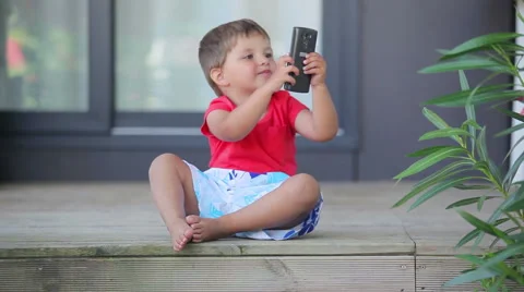 Boy playing on a mobile phone Stock Footage 61950165