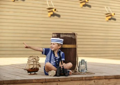 A boy is playing with a model of a sailing ship. Stock Photos