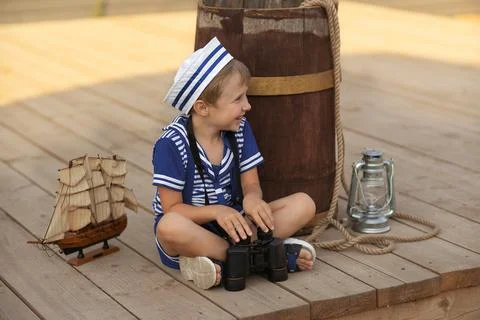 A boy is playing with a model of a sailing ship. Stock Photos
