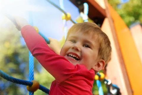 Boy playing on monkey bars Foto stock