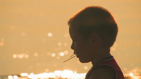Boy playing near the river at sunset Stock Footage 26091785