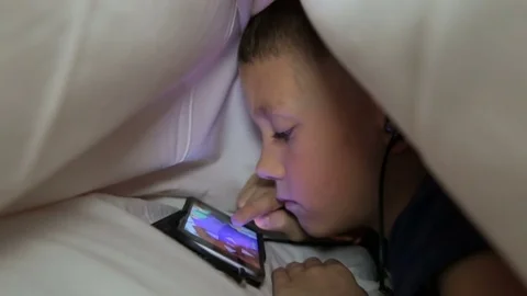 The boy is playing not the phone under the blanket Stock Footage 81564051