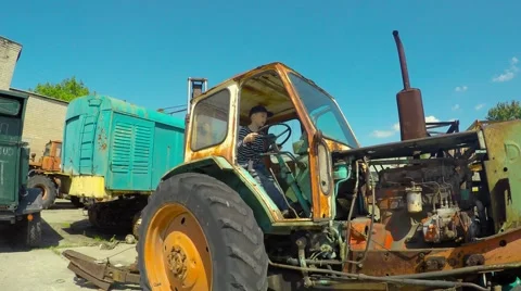 Boy playing on old tractor Video stock 51396160