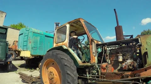 Boy playing on old tractor Stock Footage 51396177