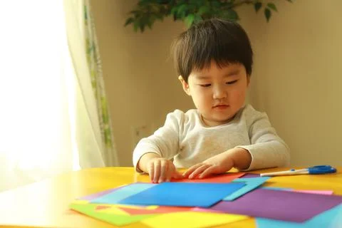 Boy playing with origami Stock Photos