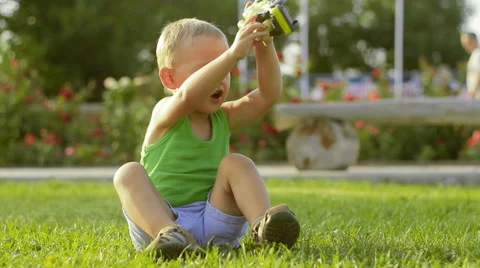 Boy playing in the park with a toy Stock Footage 65780195