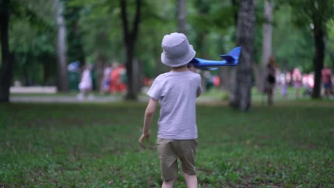 Boy playing in the park with a toy plane. Stock Footage 157296002