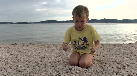 Boy playing with pebbles on the beach 動画素材 51145265