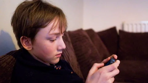 Boy playing on phone Stock Footage 88437507