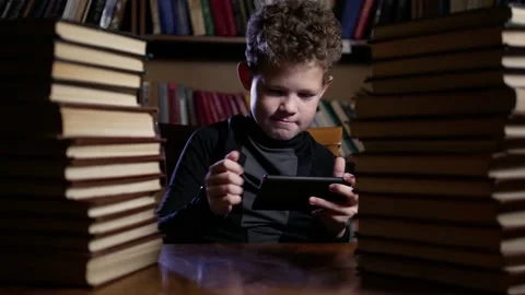 Boy playing phone loses angry books Stock Footage 146083161