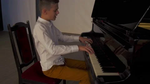 Boy playing the piano Stock Footage 141308384