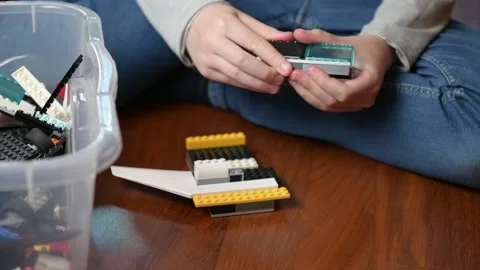 A boy is playing a plastic bricks, sitting on the floor Stock Footage 140030105
