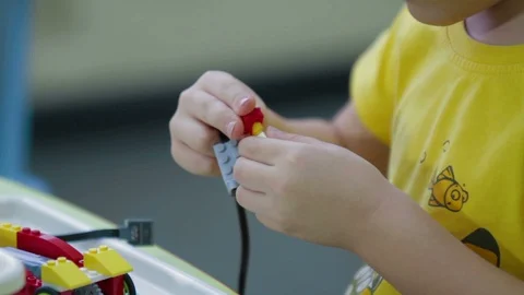 Boy playing with plastic building blocks at kindergarten Stock Footage 91143224