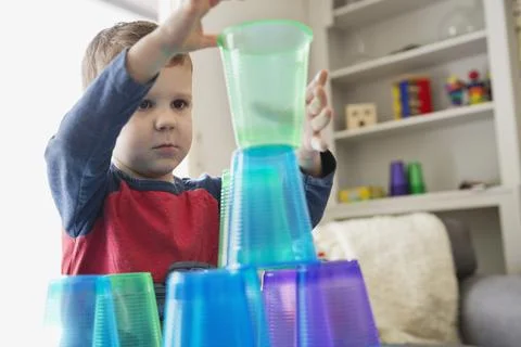 Boy playing with plastic cups at home Stock Photos