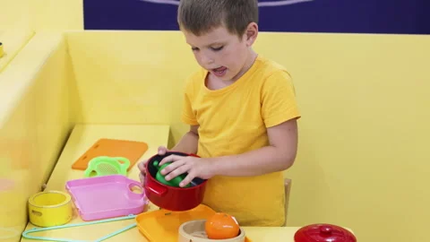 Boy playing with plastic tableware. Video stock 267057140