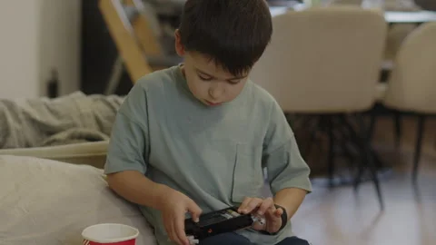 Boy playing with a plastic toy examining the instructions for assembling a model Stock Footage 241888377