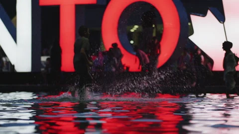 Boy playing in the pool at Nathan Phillips Square, at night. Stock Footage 217964017