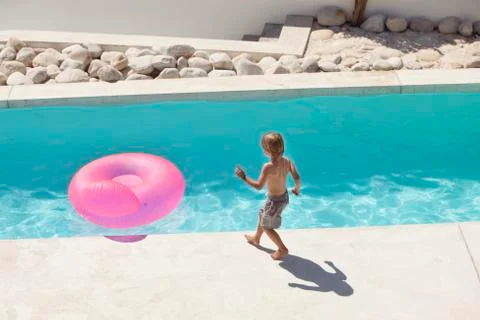 Boy playing at the poolside Stock Photos