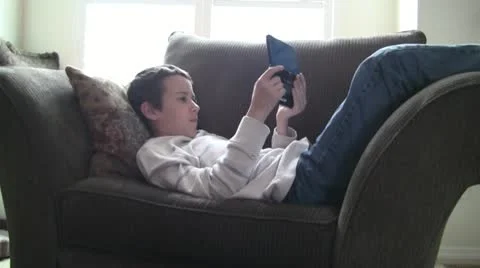 Boy playing a portable video game Видео 10877166