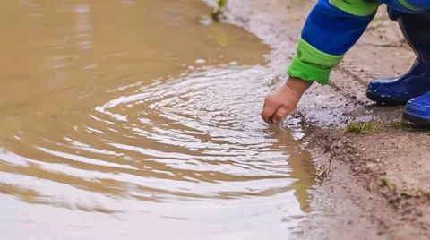 Boy playing in puddle. Stock Footage 58669710