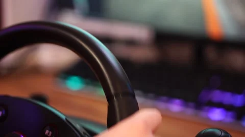 Boy playing racing simulator on computer steering wheel. hands on steering wheel Stock Footage 297450963