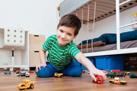 Boy playing with red double decker in his hand. Stock Photos