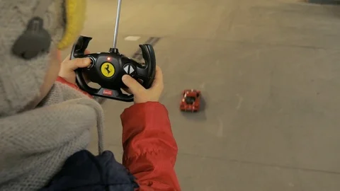 Boy playing  with a remote-controlled car in garage hall Stock Footage 101948371