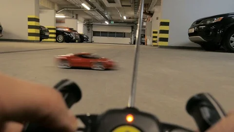 Boy playing  with a remote-controlled car in garage hall Stock Footage 101948457