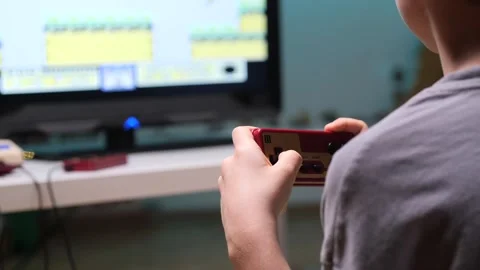 Boy playing retro video games at home using controller Video stock 302658010