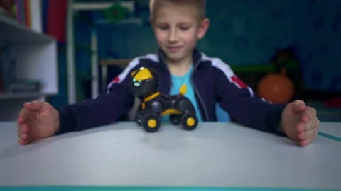 A boy is playing with a robot dog. Lonely boy dreams of a dog. Stock Footage 133259601