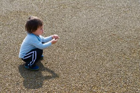 Boy Playing with Rock Stock Photos