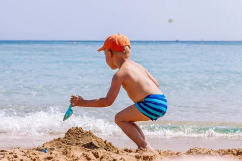 Boy playing in the sand and waves on the beach Stock Photos